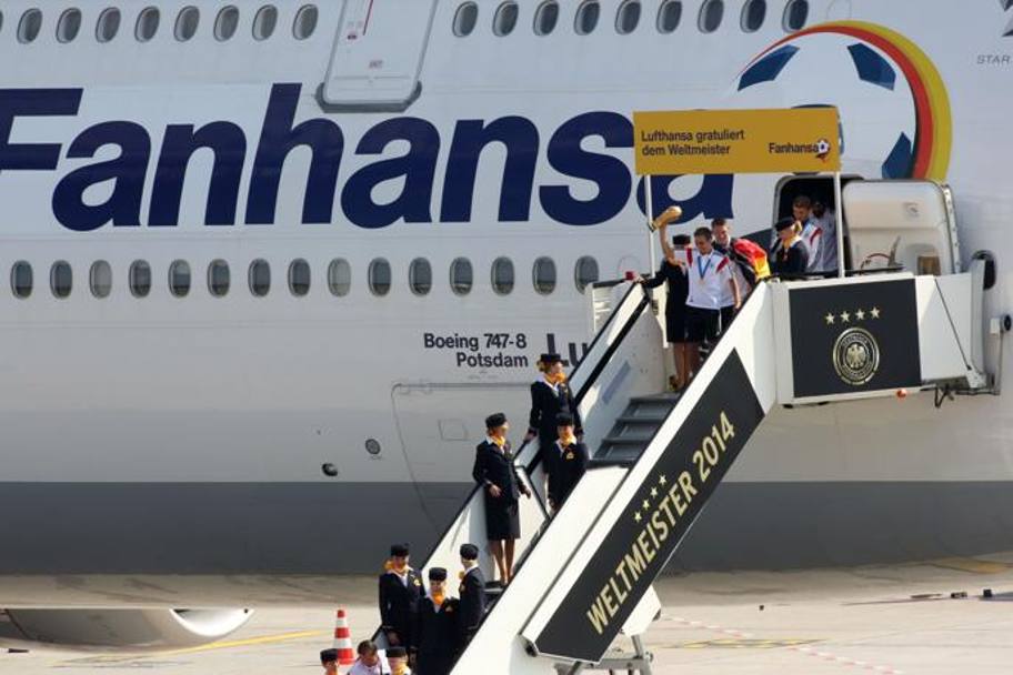  Il primo ad uscire dal portello del Boeing 747 della Lufthansa  stato il capitano Philipp Lahm, con la coppa in mano. Afp